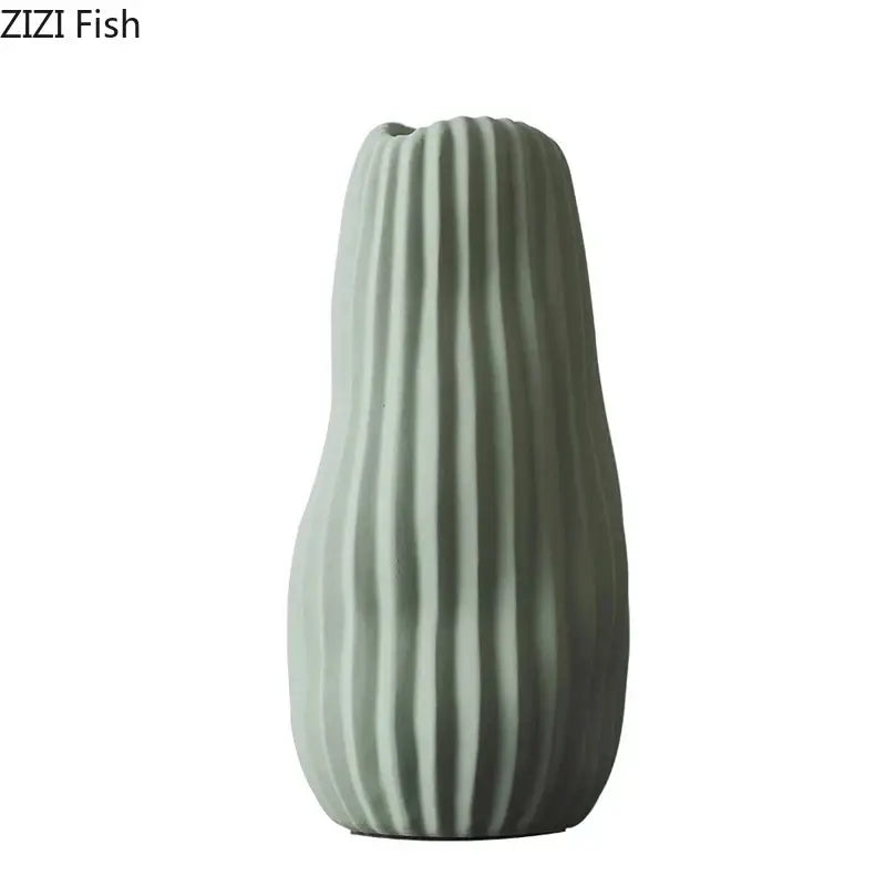 A sleek matte sage green irregular ceramic vase with vertical ridges from decorbites irregular ceramic vase trio decor