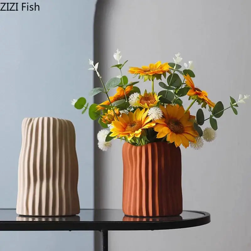 Modern irregular ceramic vase by decorbites with ribbed terra-cotta texture holding yellow sunflowers for living room decor