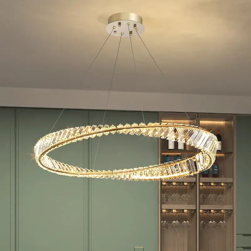 Modern irregular gold steel pendant light with a circular gold-toned frame and clear crystal facets for elegant decorbites decor