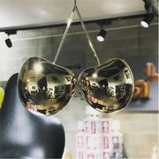 Modern italian gold pendant light featuring a shiny metallic cherry-shaped decorbites gold pendant for dining room decor