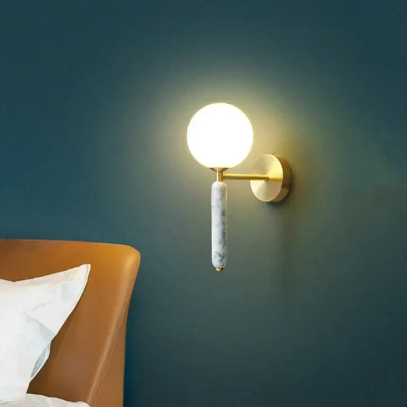 Gold-toned wall lamp with italian green marble stem and glass globe by decorbites for modern bedroom decor