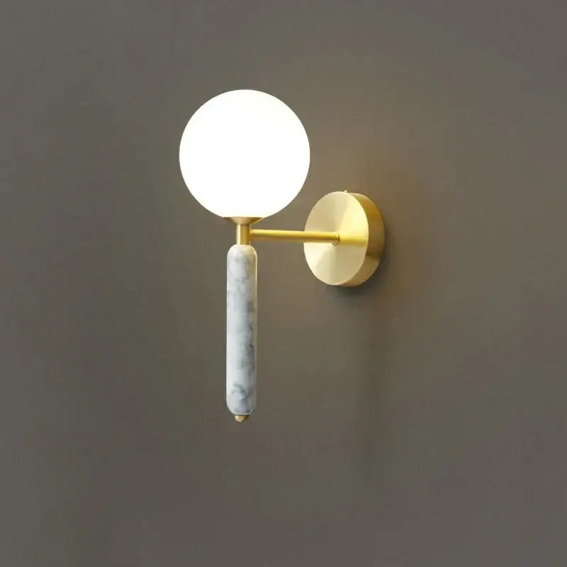 Modern italian green marble wall lamp featuring a gold-toned sconce with frosted glass globe and marble-textured stem