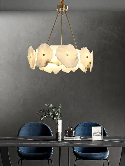 A modern ceiling light with ivory white petal-shaped lampshades and gold-toned chains for decorbites ivory white marble decor
