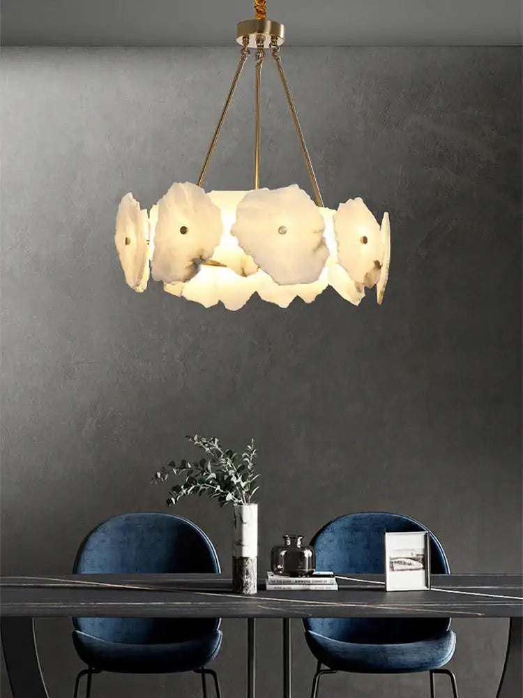 A modern ceiling light with ivory white petal-shaped lampshades and gold-toned chains for decorbites ivory white marble decor