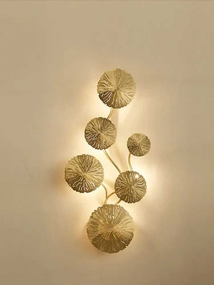Modern leaf gold iron wall sconce with intricately detailed circular leaf elements in a vertical vine pattern by decorbites iron wall