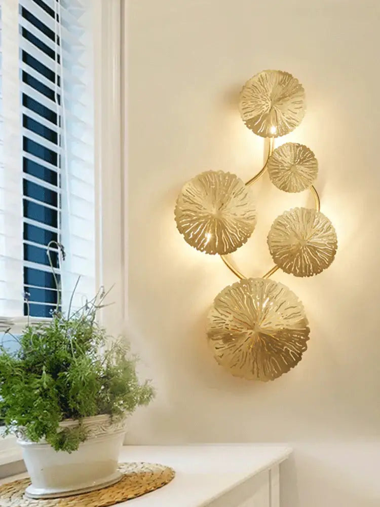 Modern leaf gold iron wall sconce with five circular leaf-like discs in gold-toned decorbites iron wall design