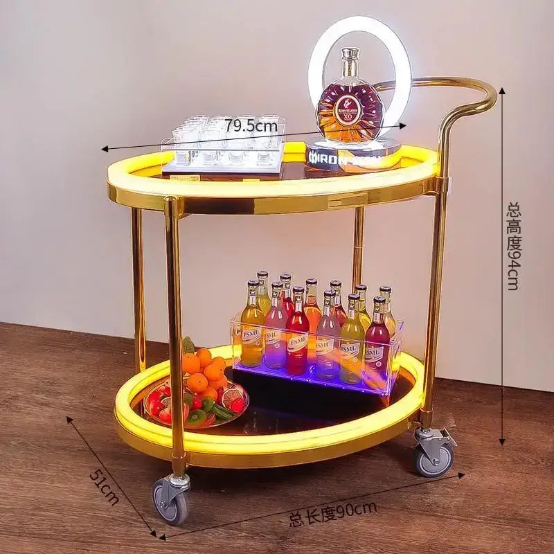 Gold-finished two-tier beauty salon trolley with illuminated yellow led rings and silver caster wheels for salon storage