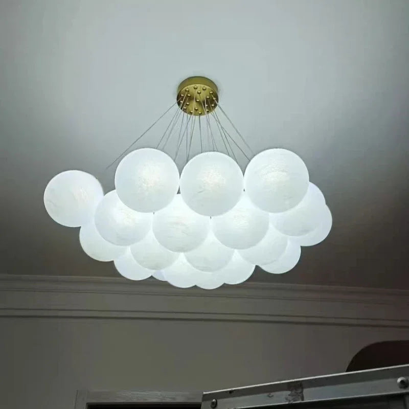 A modern luxury led cloud-shaped chandelier with frosted white glass globes and brass finish for living room lighting