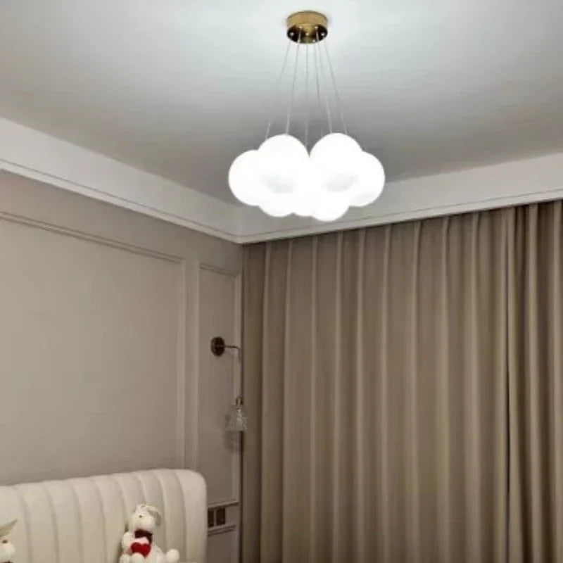 A modern luxury led cloud-shaped pendant light with frosted white glass shade and brass mount for living room lighting