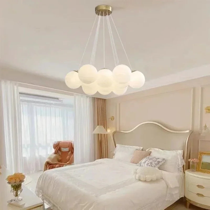 A modern led chandelier with frosted milk white glass spheres and gold fixture for luxury led living room lighting decor