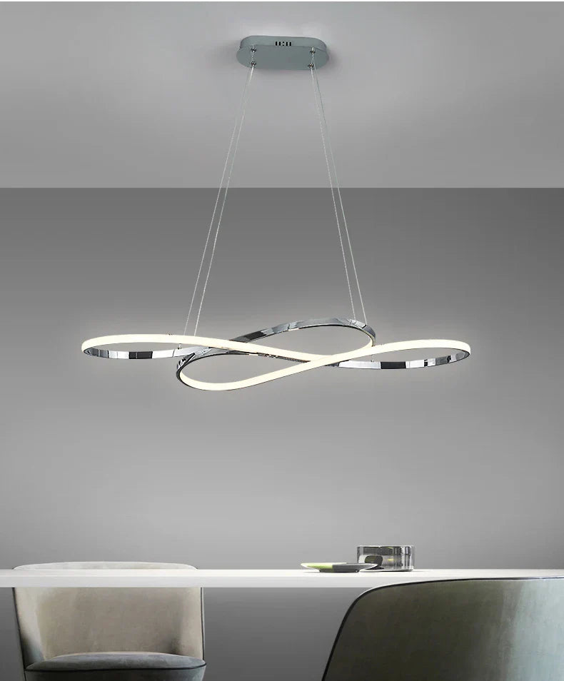Modern chrome infinity loop pendant light with sleek illuminated rings featuring remote dimming for dining room decor