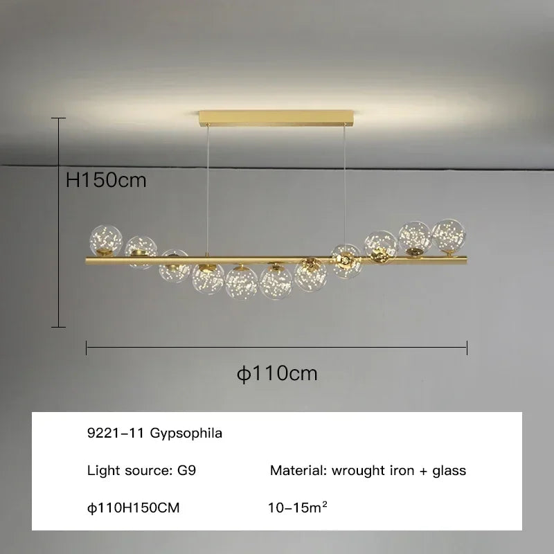 Gold-toned modern LED long ceiling chandelier with clear glass globe bulbs on wrought iron bar for dining room decor