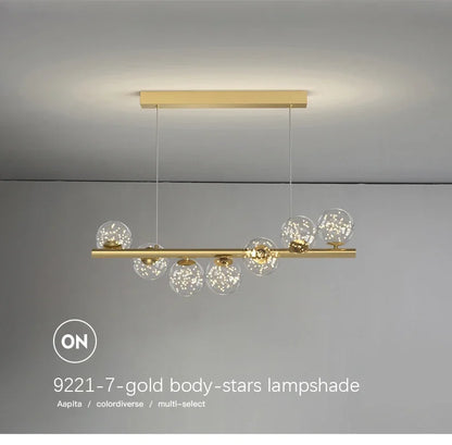 Gold-toned modern LED pendant lamp with a sleek horizontal bar and seven clear glass globe shades with star sparkles