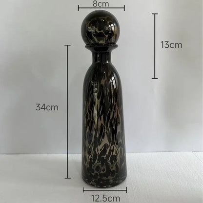 A 34cm tall sleek glass decanter with glossy black and gold leopard texture for modern dining room decor