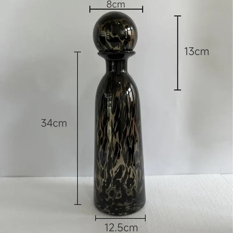 A 34cm tall sleek glass decanter with glossy black and gold leopard texture for modern dining room decor