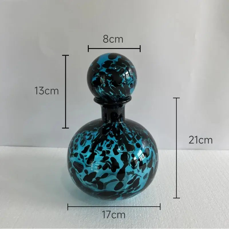 Glossy blue and black marbled glass perfume bottle with spherical stopper featuring decorbites leopard texture design