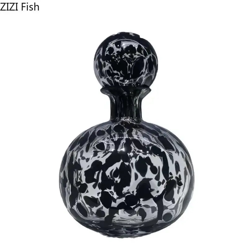 A sleek black and clear glass modern leopard texture glass vase with a marbled design and spherical stopper for dining room decorbites