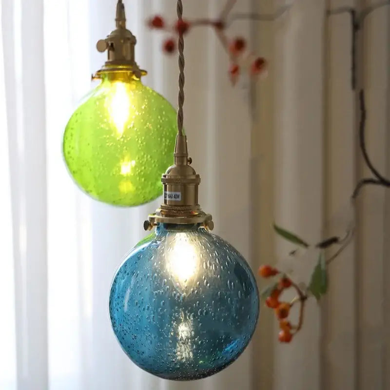 Two spherical glass pendant lights in lime green and teal blue bubble glass ball design by decorbites for dining room decor