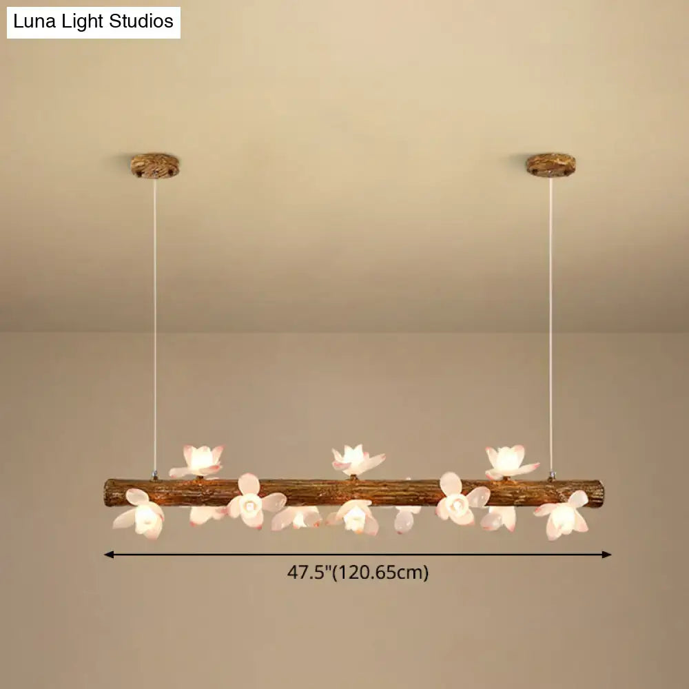 Rustic wooden log brown modern linear island pendant metal lamp adorned with delicate white flower fixtures by decorbites
