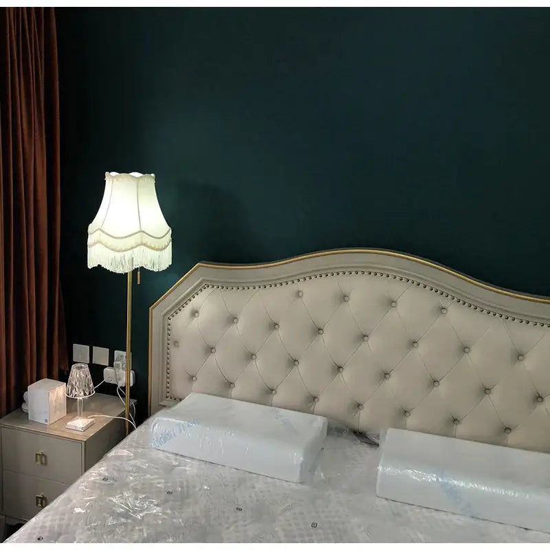 Cream tufted leather headboard with gold trim and nailhead detailing complements decorbites fringed cloth lampshade decor