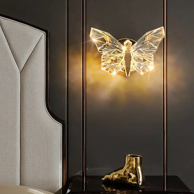 Modern luxury crystal butterfly wall lamp with faceted wings and warm golden glow perfect for bedroom decor