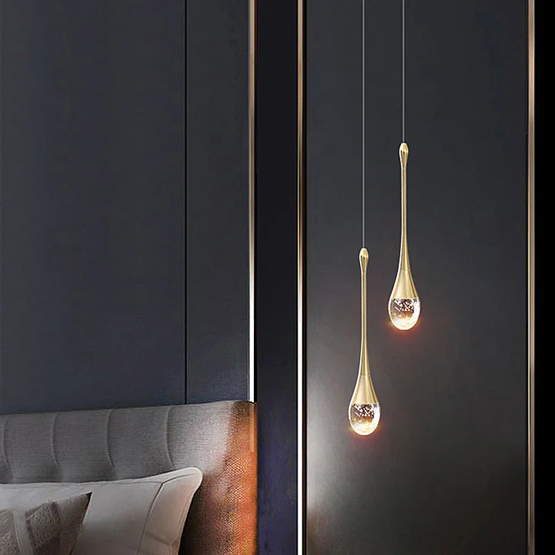 Two elegant gold-toned crystal pendant lamps with clear glass bodies and sparkling elements for modern home decor