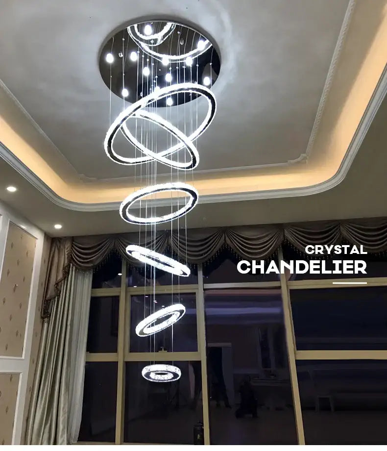 A modern luxury decorbites crystal rings chandelier with glowing interlocking circular rings for staircase lighting