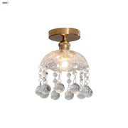 A modern luxury decorbites crystal glass ceiling lamp with brass finish and faceted spherical crystals for living room