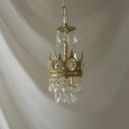 A delicate gold-toned decorbites crystal crown chandelier with clear crystals and oval stones for living room decor