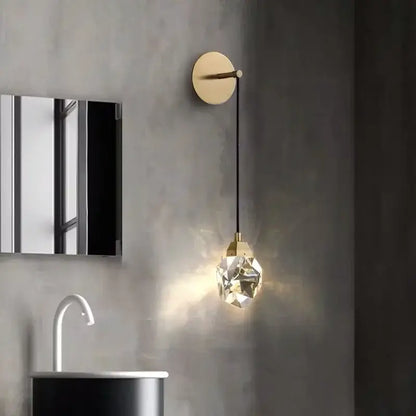 A modern luxury gold crystal led wall sconce with a faceted glass globe and black cord for bedroom decorbites crystal led