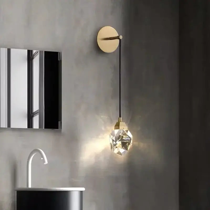 A modern luxury gold crystal led wall sconce with a faceted glass globe and black cord for bedroom decorbites crystal led
