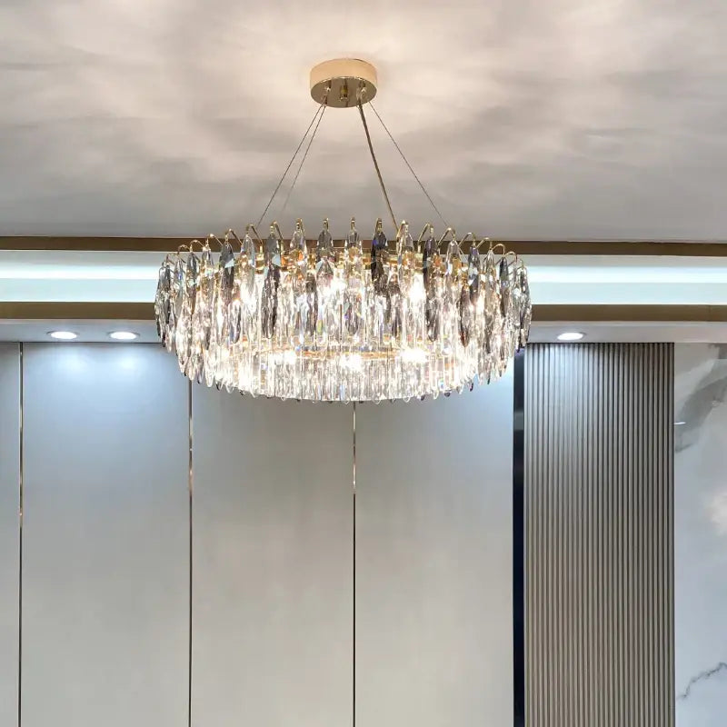 A modern luxury decorbites crystal atmosphere chandelier with gold-toned frame and clear glass prisms for dining room
