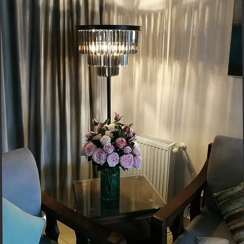 A modern luxury gray crystal black standing floor lamp with a black metal frame and cascading clear crystal prisms for decorbites