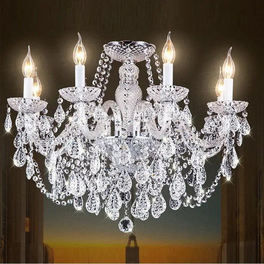 A modern luxury lighting crystal candle chandelier with five lit bulbs and teardrop crystals for dining room use