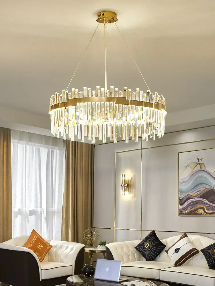 Modern luxury spectrum gold crystal chandelier with cascading clear crystal rods and a circular brass frame for dining room