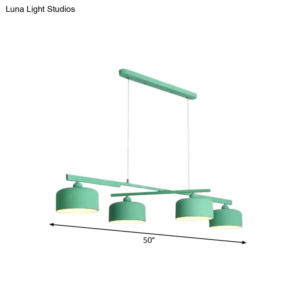 Modern mint green metal pendant light with four cylindrical shades and adjustable chain cord length for dining table