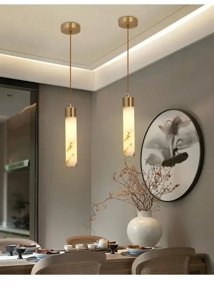 Two elegant gold-finished modern marble and copper led pendant lights with translucent cylindrical shades for bedroom decorbites copper led pendant