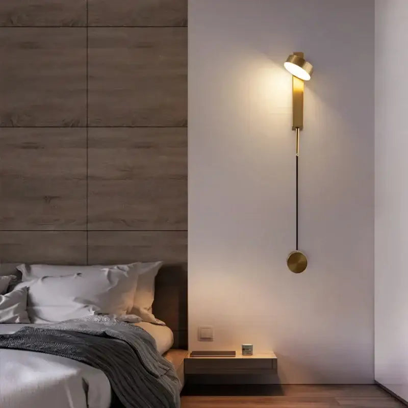Gold-toned wall lamp with adjustable head and circular base featured in decorbites black rotating led bedroom sconce