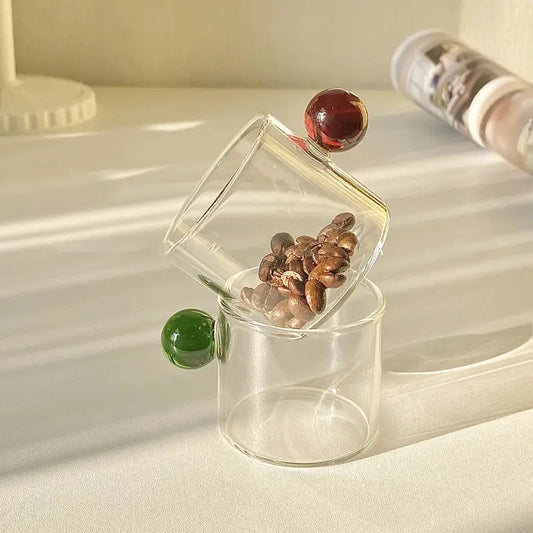 Modern marble sphere glass espresso cups kitchen set with colorful handles and one tipped over spilling beans