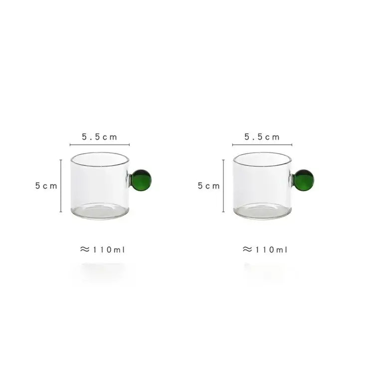 Clear glass espresso cups with vibrant green marble sphere handles each holding 110ml in a modern kitchen set