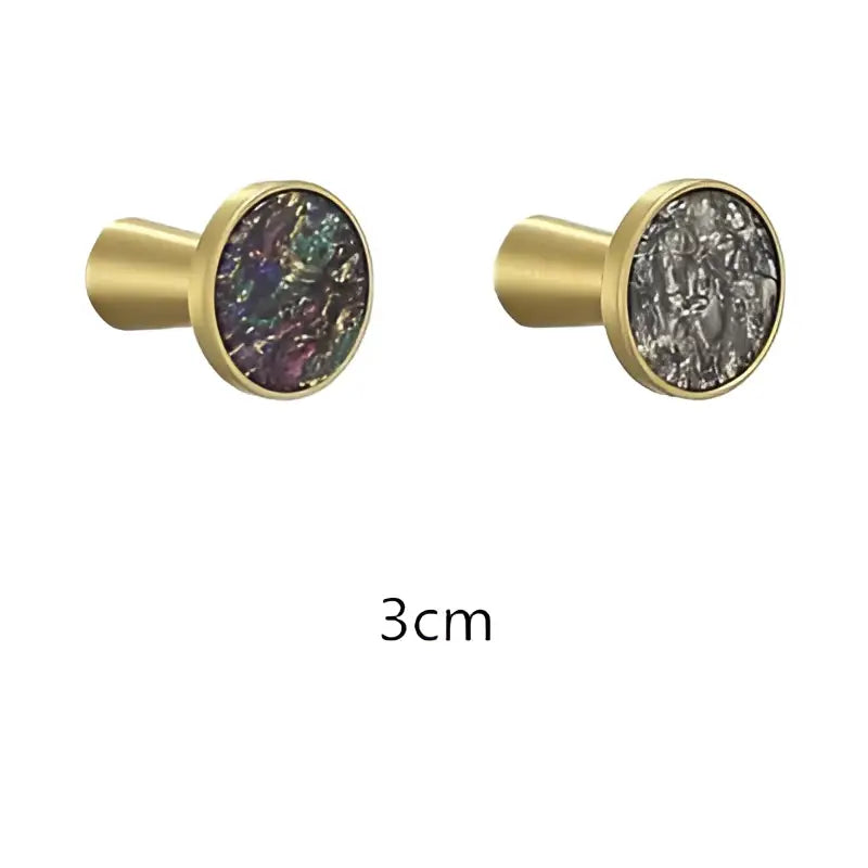 Modern marbled stone and decorbites brushed gold towel hook featuring gold-toned cabinet knobs with iridescent inserts