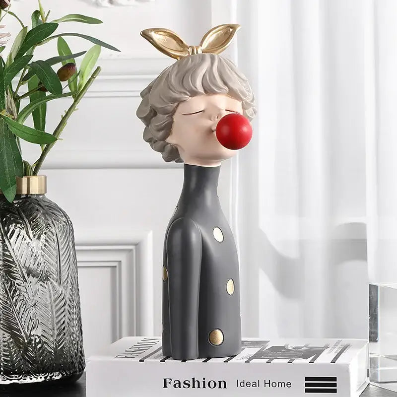 Gray resin bubble gum girl statue with gold bunny ears and red nose in black coat with gold buttons for bedroom decor