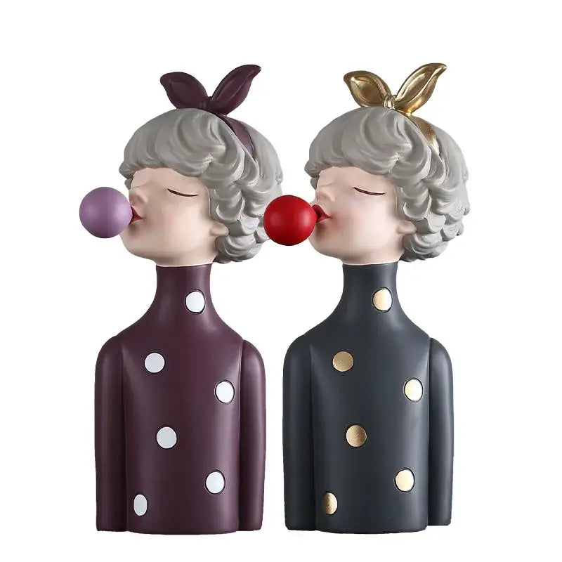 Modern maroon and silver bubble gum girl statue featuring two figurines with gray curly hair and colorful polka-dot outfits
