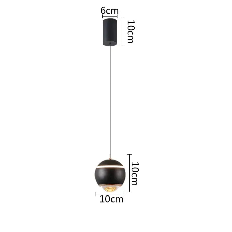 Modern matte black ball pendant light with gold accent and thin cord, ideal for bedroom and kitchen island lighting