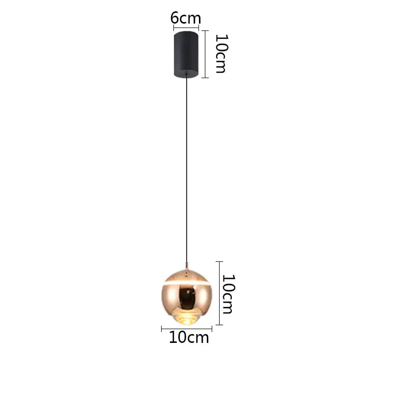 A sleek polished gold ball pendant light with black cylindrical mount ideal for bedroom and kitchen island lighting