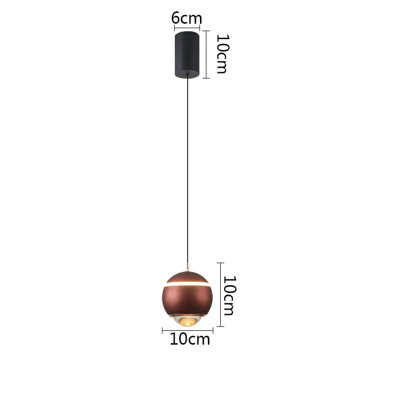 A sleek copper-finished ball pendant light with a black mount and illuminated base for modern bedrooms and kitchen islands