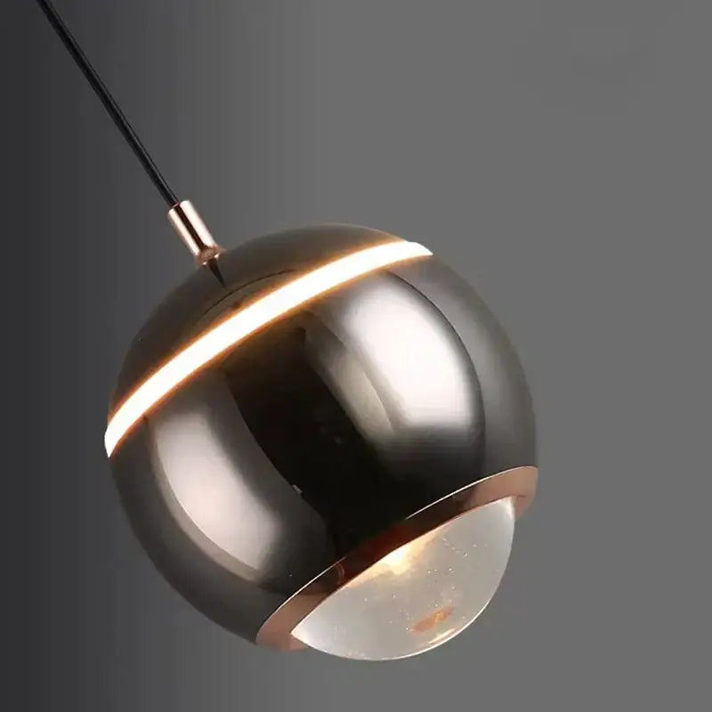 Modern matte ball pendant lights featuring a sleek spherical design with brushed metallic finish and copper accents for bedroom and kitchen island lighting