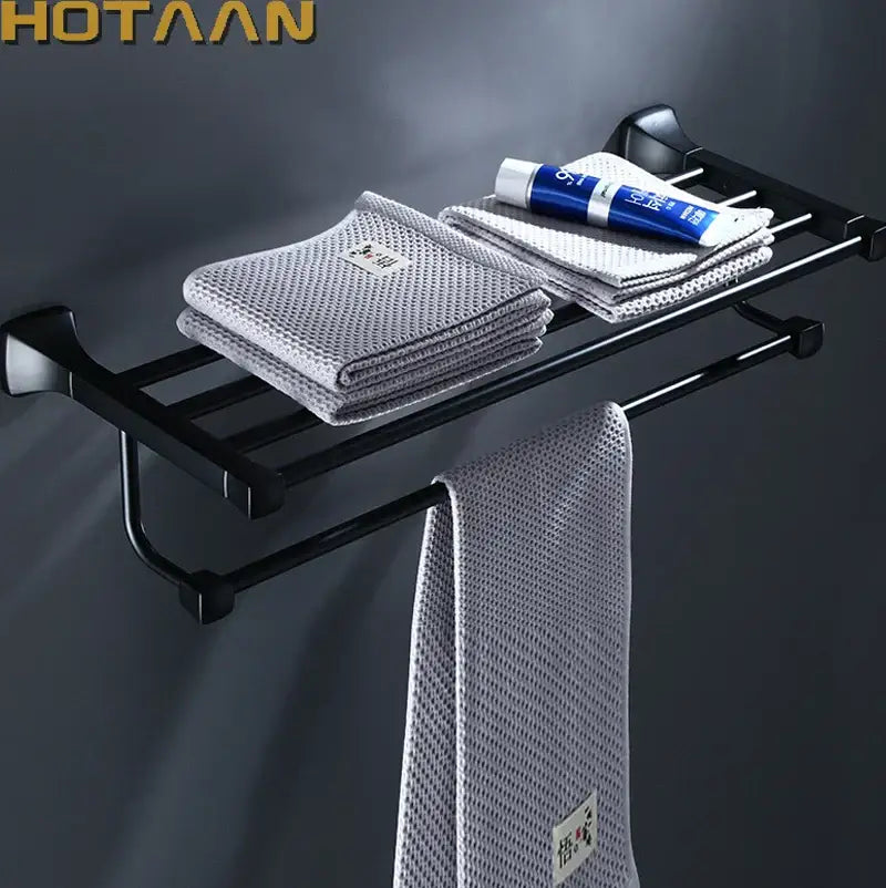 Modern matte black aluminum towel rack by decorbites holding gray mesh towels and a blue toothpaste tube