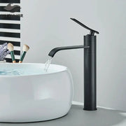 Modern matte black basin faucet mixer with curved spout flowing water into white ceramic sink decorbites basin faucet