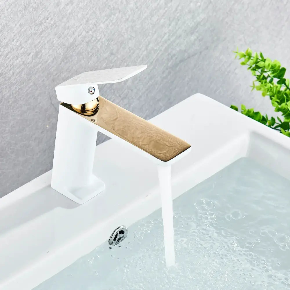 Modern white and gold-toned decorbites black basin mixer tap with sleek rectangular spout and minimalist handle design